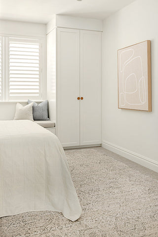 Modern bedroom with a bed, wardrobe, and abstract art on the wall.