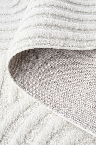 Close-up of a textured white rug with a soft focus background