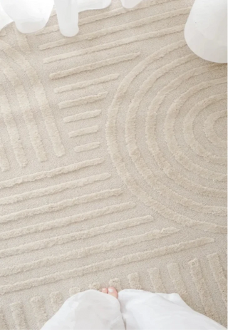 Close-up of a textured beige rug with a geometric pattern.