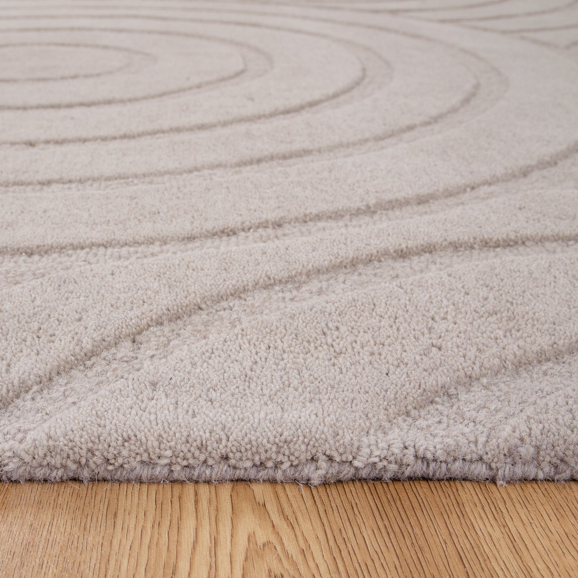 Close up view of the plush wool pile of the Ellipse Beige Wool Rug | Simple Style Co